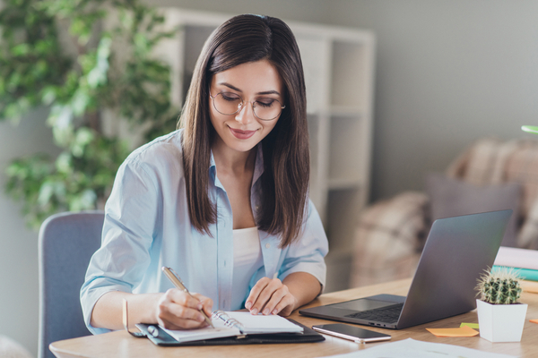 a woman writing in her notebook 