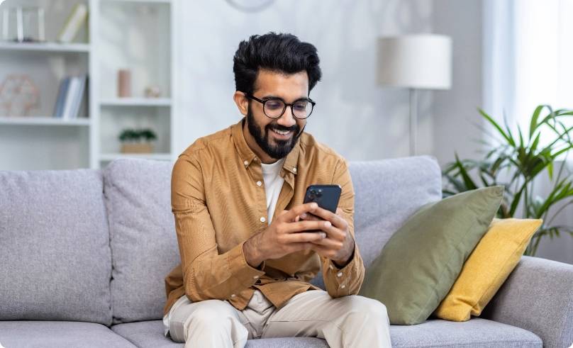 A man sitting on the couch with his phone