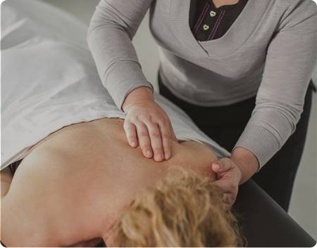 A woman receiving a massage while lying on her back