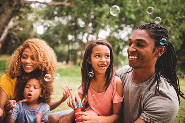 family outside blowing bubbles