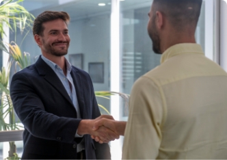 Deux professionnels se serrent la main dans un environnement de bureau.