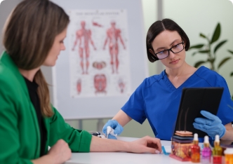 Une professionnelle de la santé examine une patiente au bureau à l'aide d'une tablette.